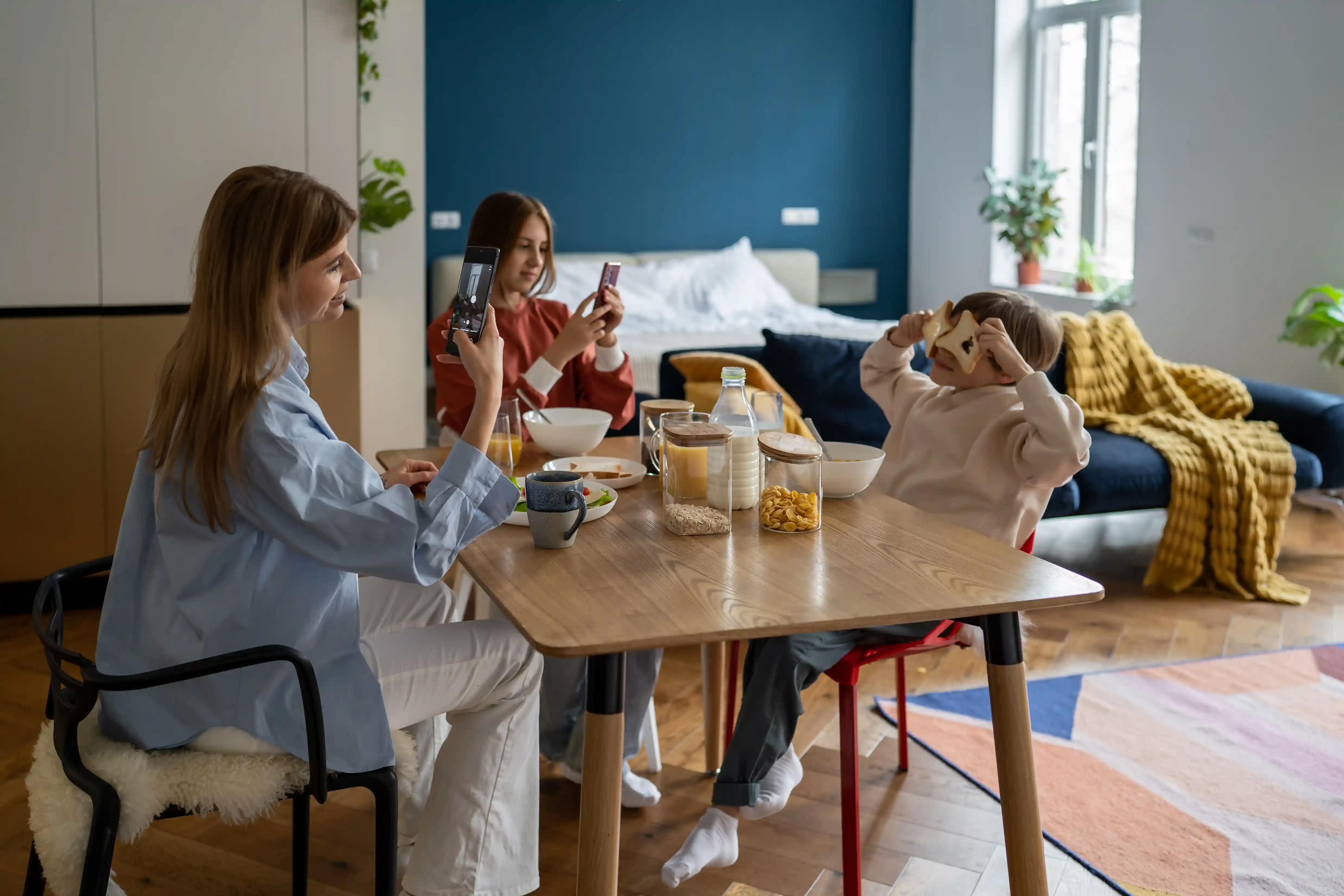 Family having breakfast at a table in a modern apartment