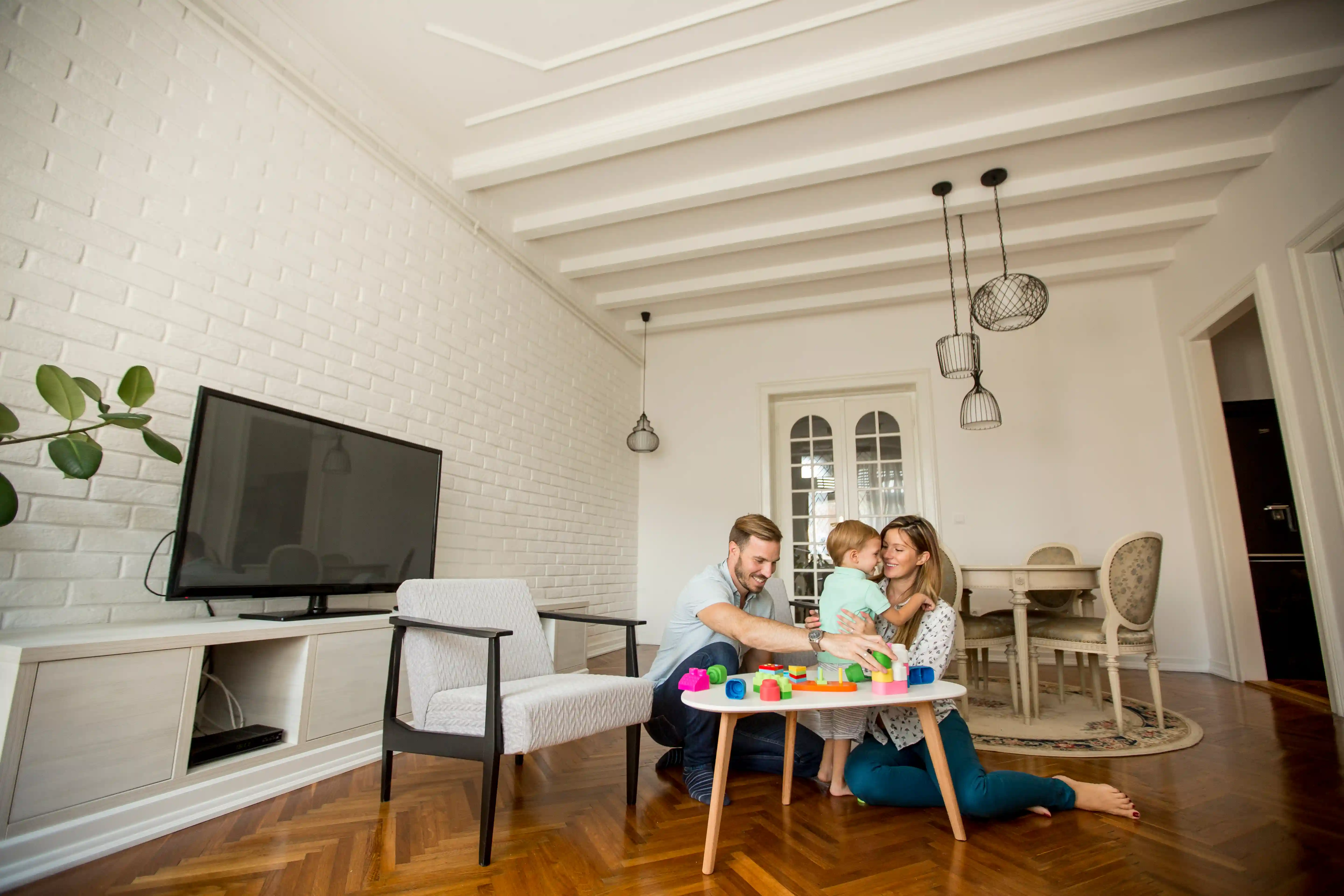 Family playing with toddler in a bright living room