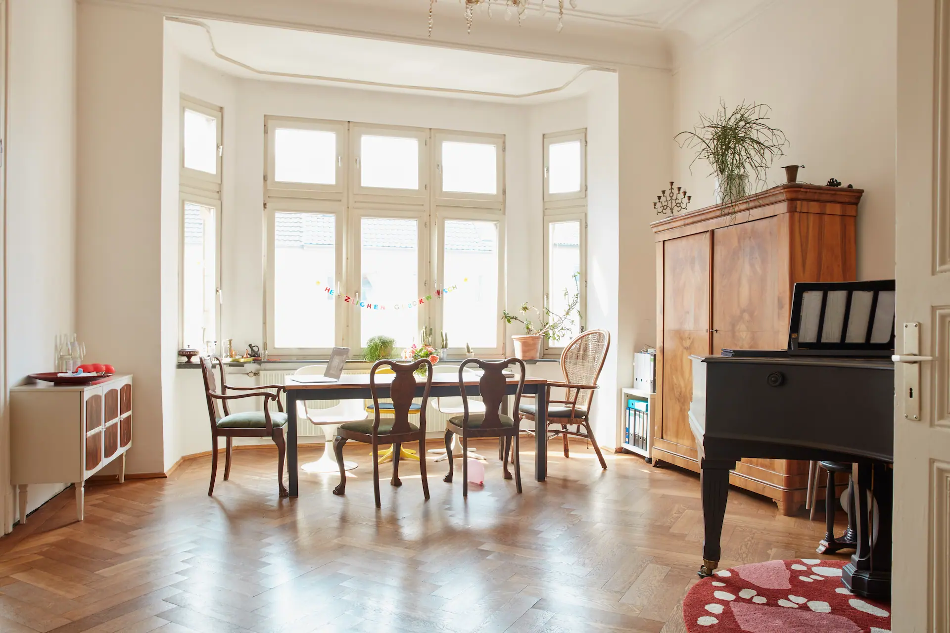 Friends enjoying pizza and drinks together in a Berlin co-living apartment.