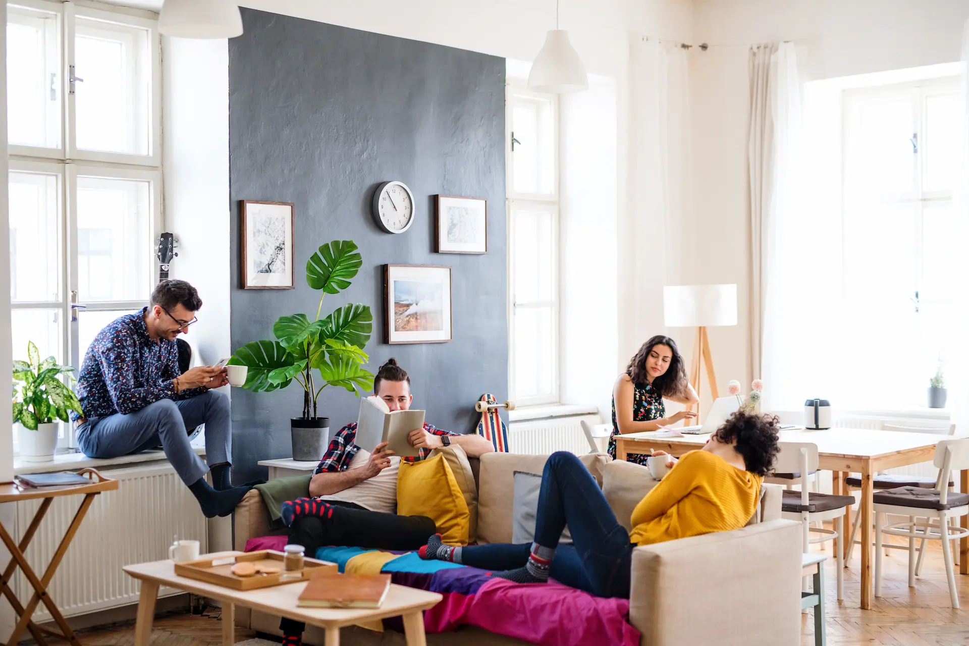 Young flatmates clinking glasses at breakfast in the kitchen of a Berlin co-living apartment.
