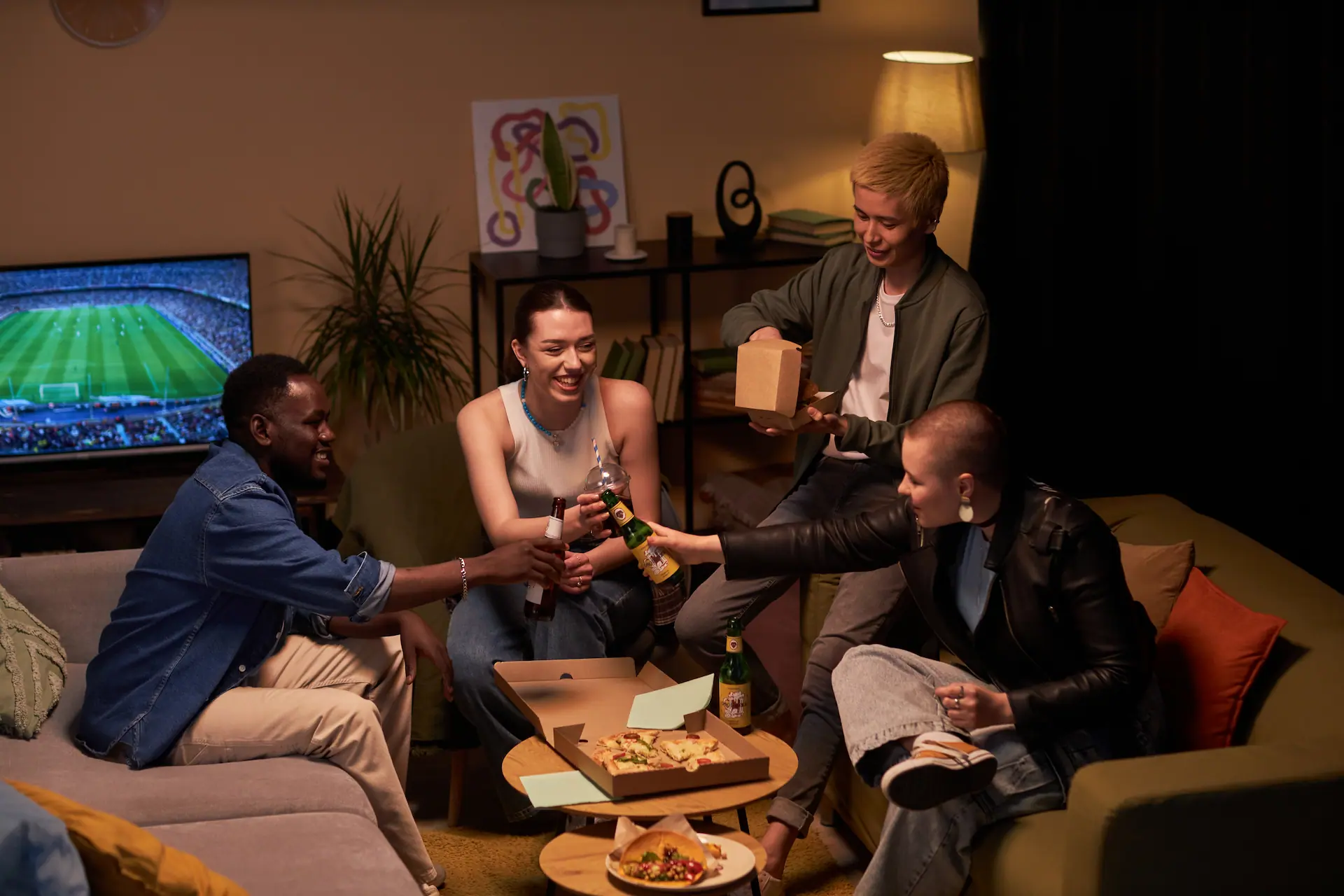 Group of young adults laughing on a sofa in a modern Berlin co-living apartment.