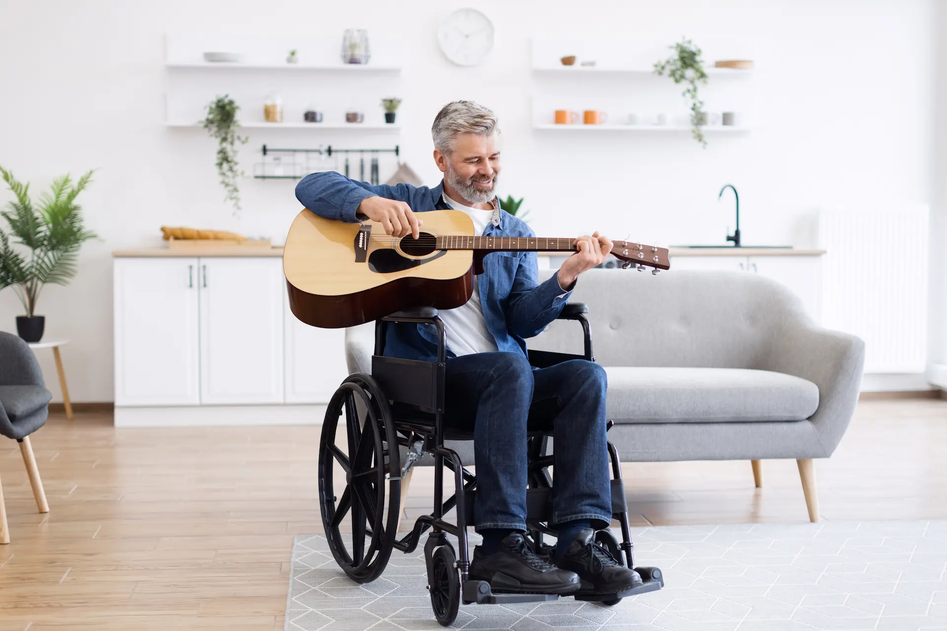 Man in a wheelchair playing guitar in a cozy Berlin apartment – accessible living with joy and comfort