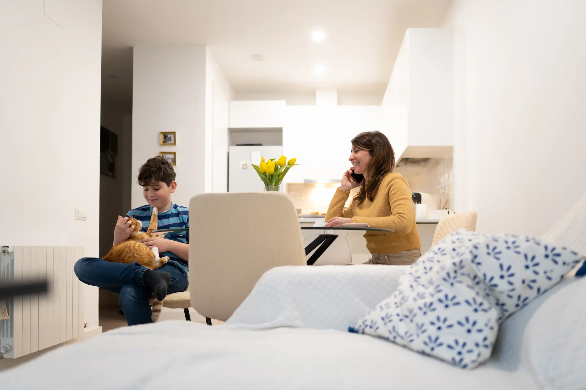 Mother and son with cat in bright apartment – everyday scene for household insurance at Berlin Direkt