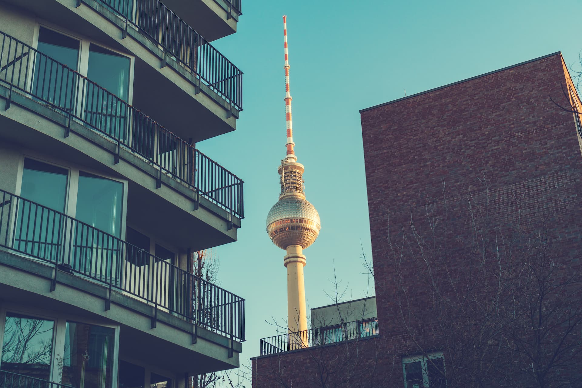 Berlin TV Tower framed by modern residential buildings in an urban housing area.