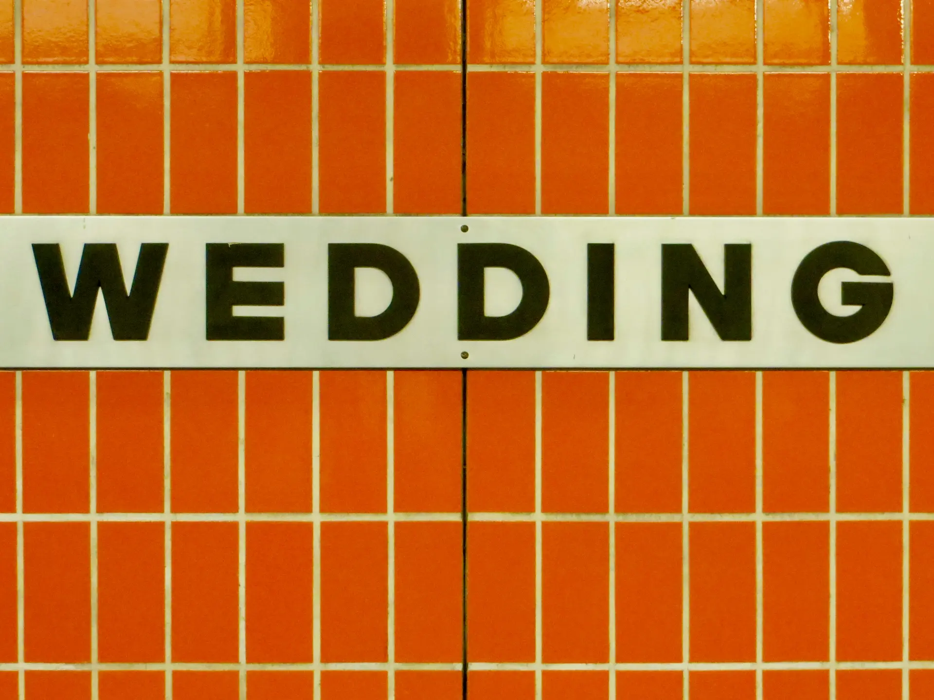“Wedding” subway sign on an orange tiled wall