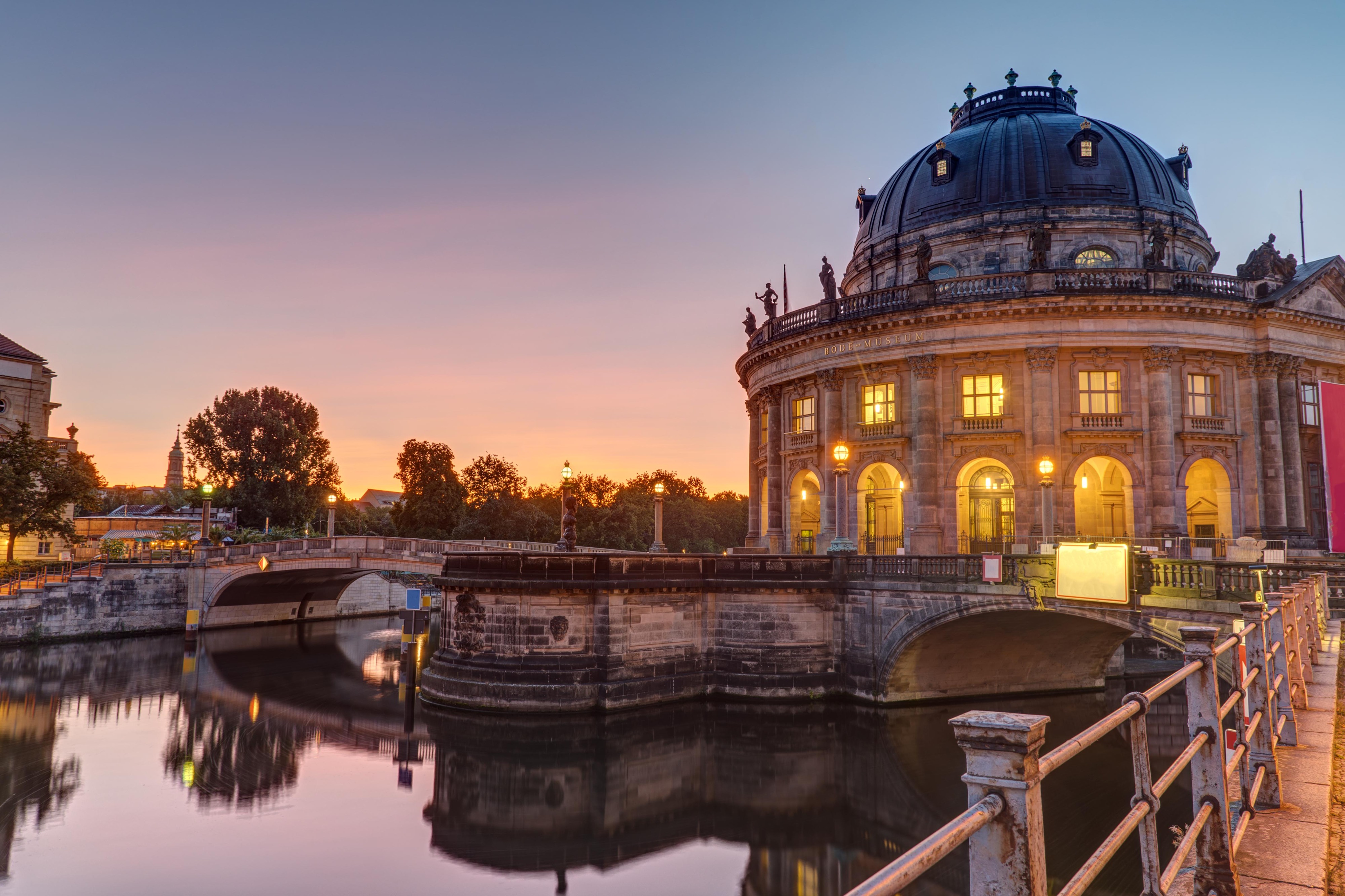 The Bode Museum in Berlin on the Spree River at sunset, with reflections on the water.