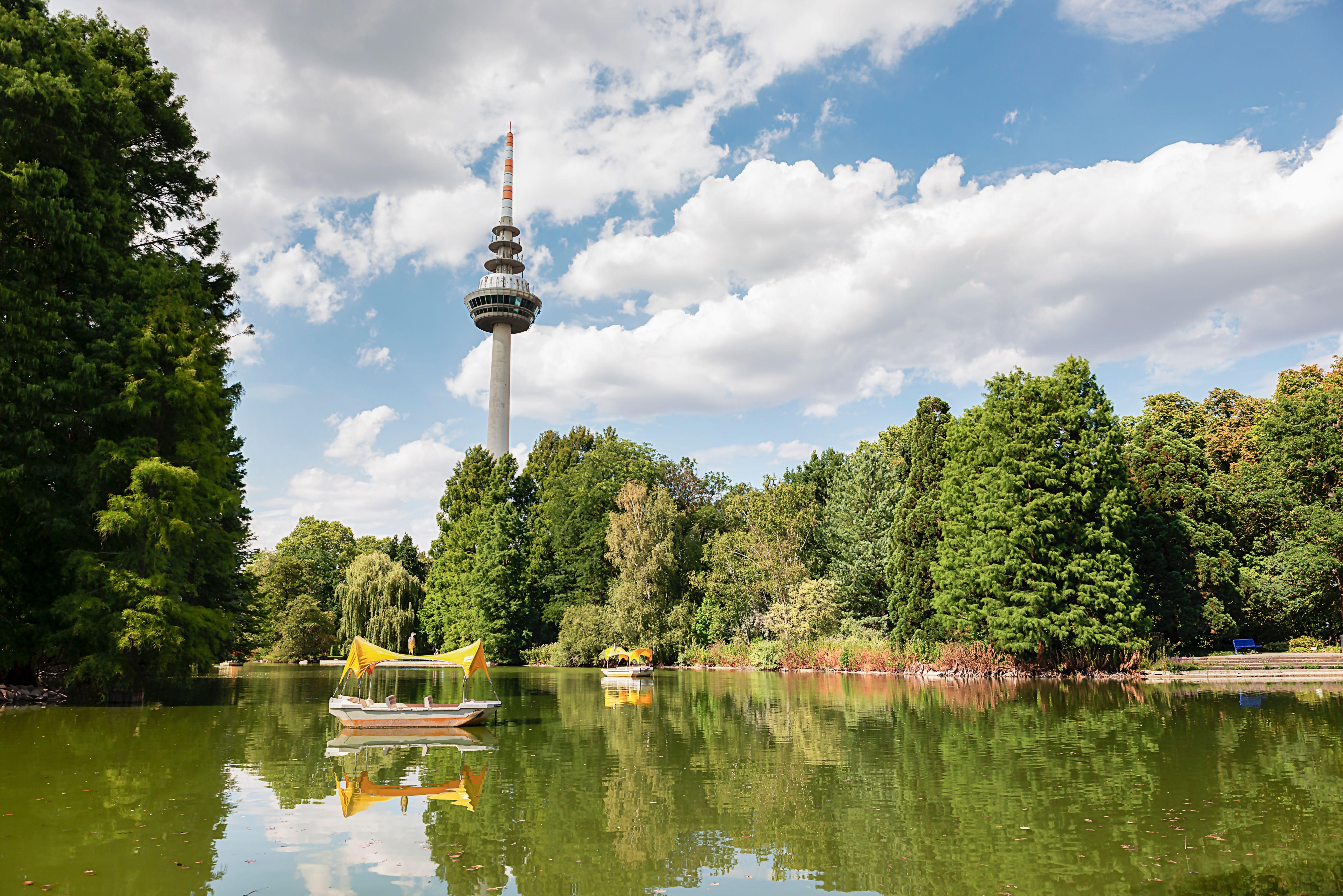 Park view in Berlin with a lake, boats, and the TV tower in the background.