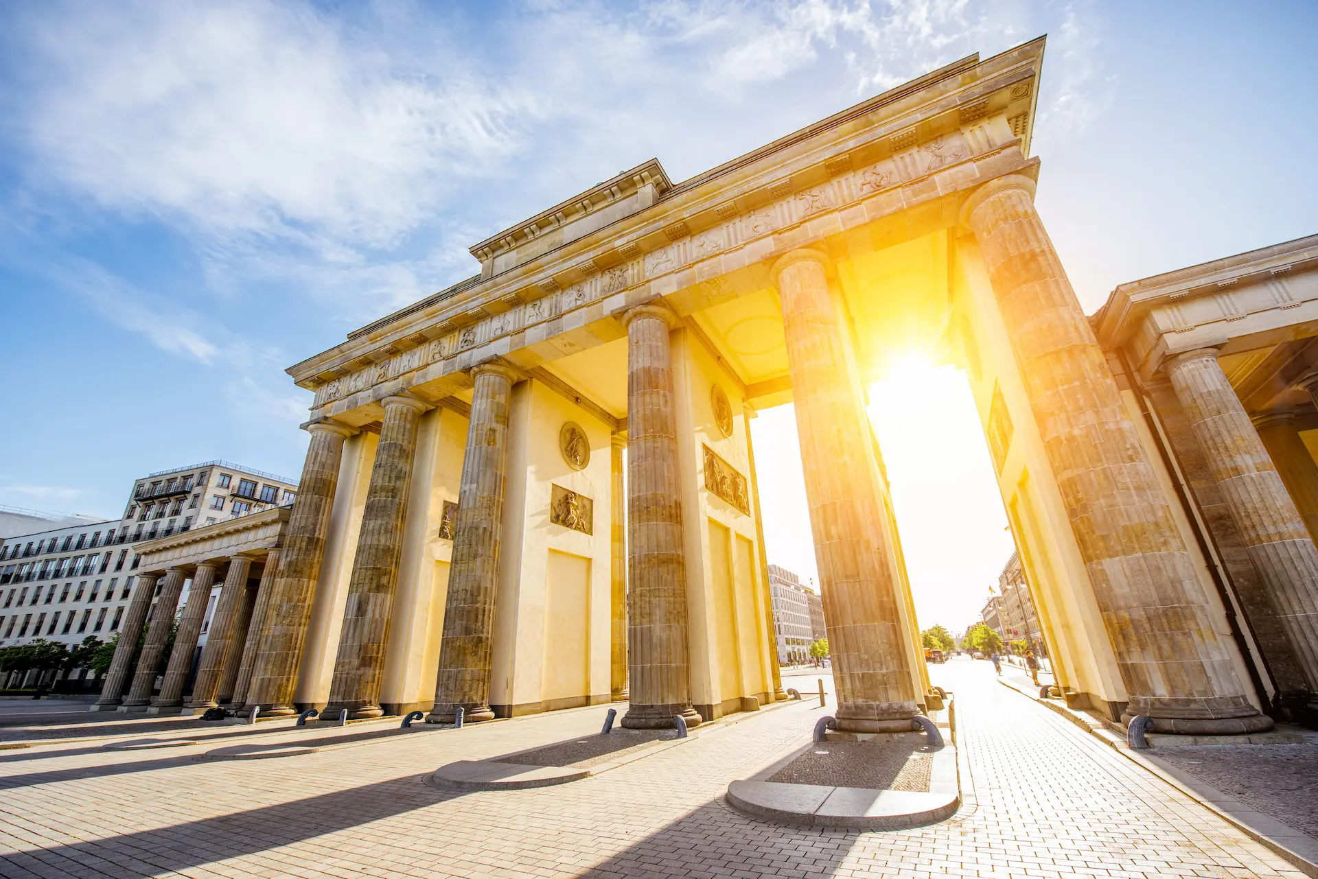 Brandenburg Gate in Berlin with sunlight streaming between the columns