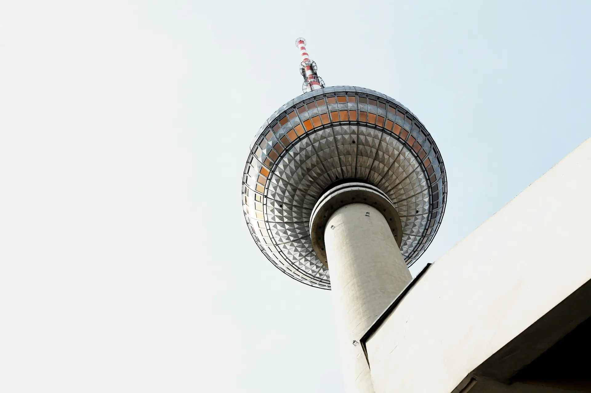 Low-angle view of a tall observation tower against a pale sky.