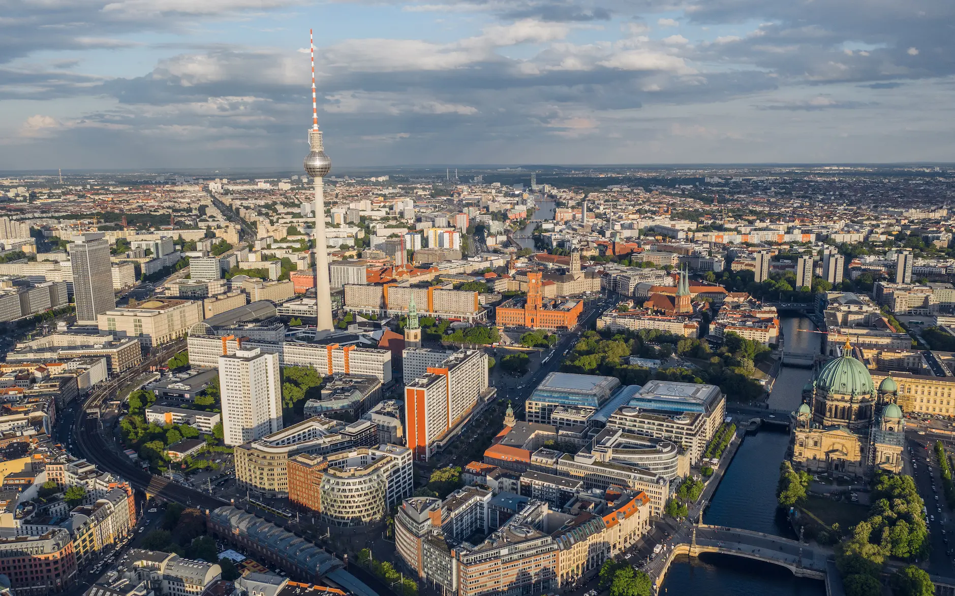 Aerial view of Berlin featuring the TV tower, river, and dense city center.