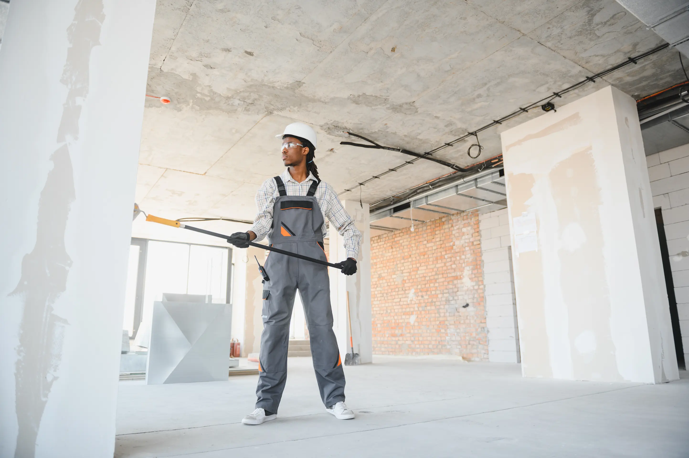 Construction worker wearing a helmet working on an interior wall