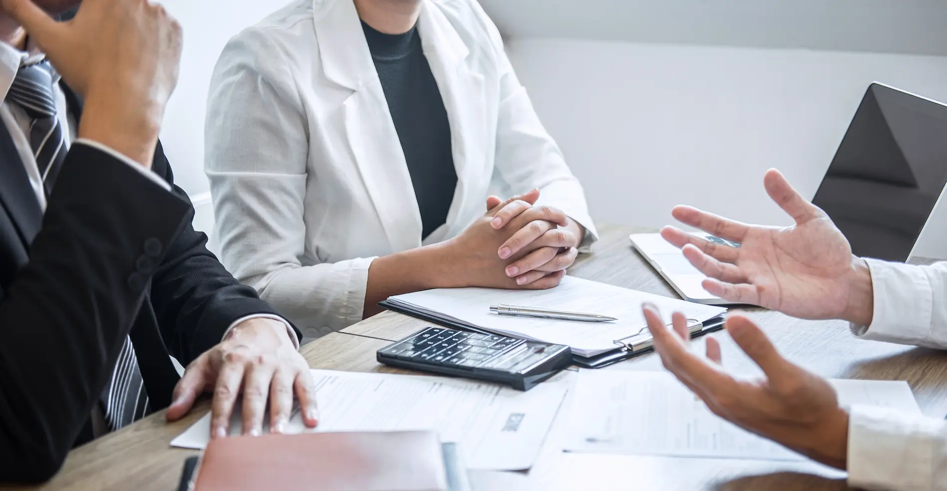 People sitting at a table discussing documents during a consultation.