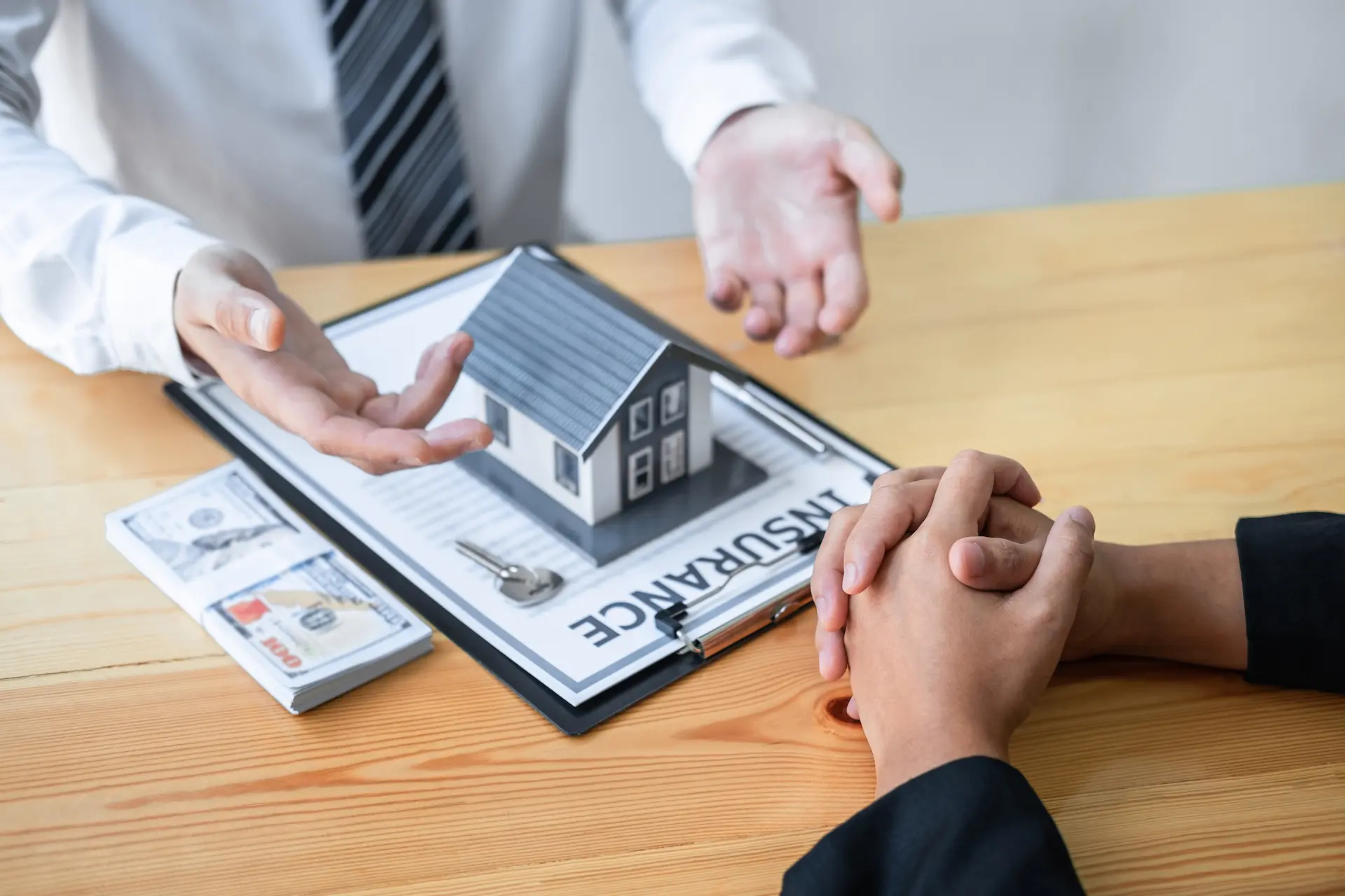 Home purchase consultation with model house and documents