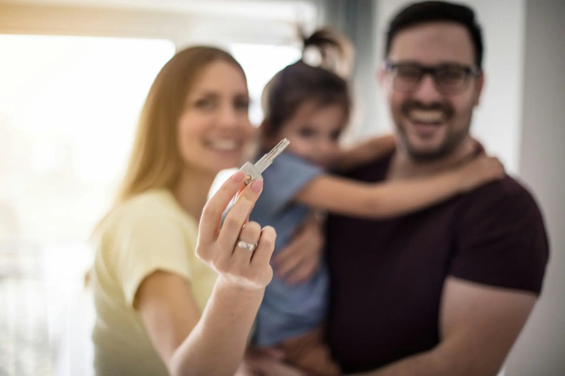 Family proudly holding a house key.