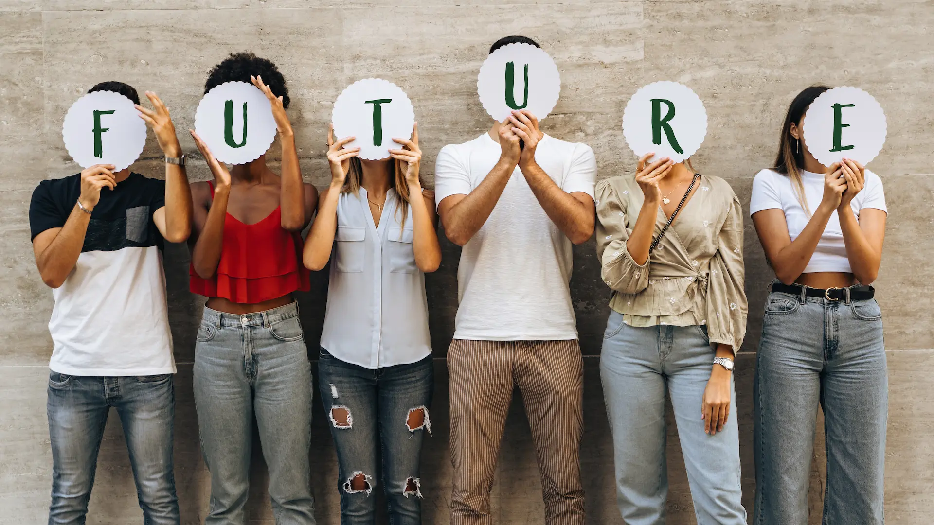 Group of young people holding signs spelling “Future” in front of their faces.