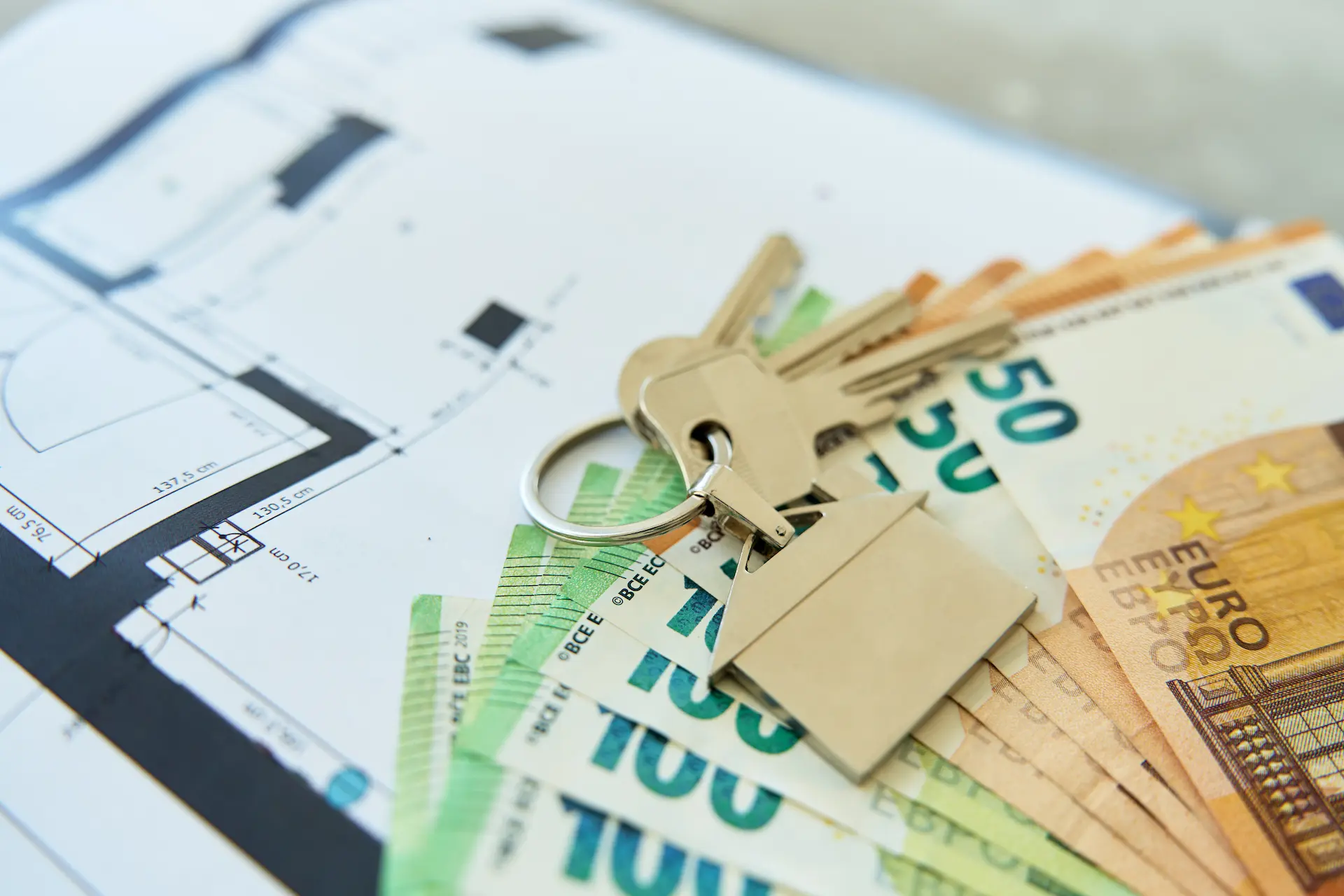 House keys on banknotes and floor plan