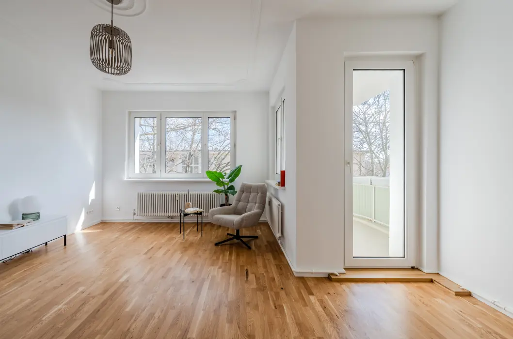 Wohnzimmer mit Balkonzugang und Parkett