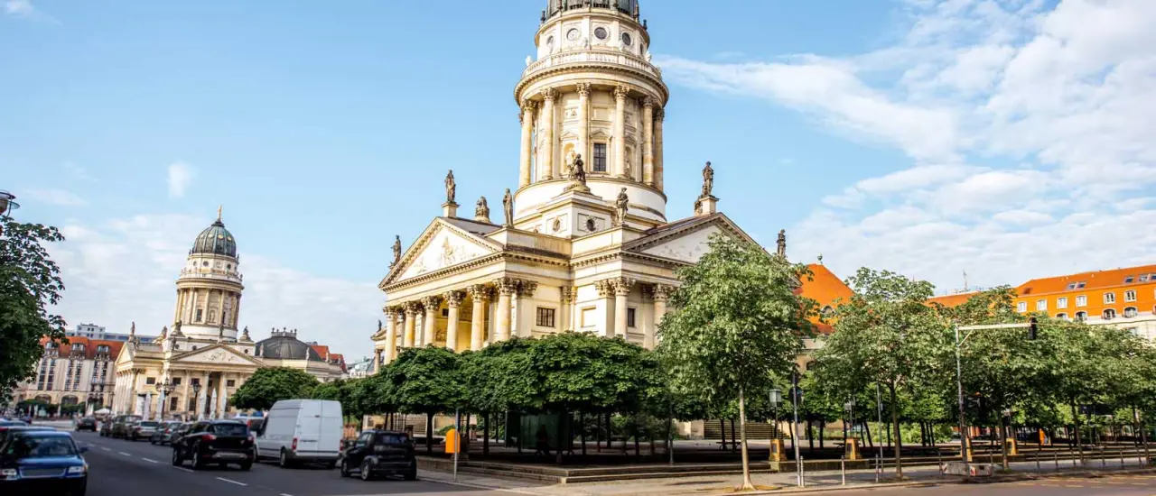 Modern eingerichtetes Wohnzimmer mit Holzboden, Esstisch und Blumen.