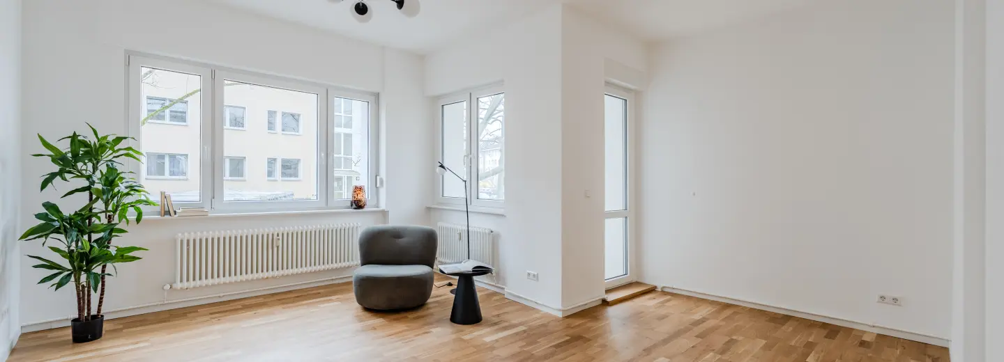 Wohnzimmer mit Parkettboden und Balkontür