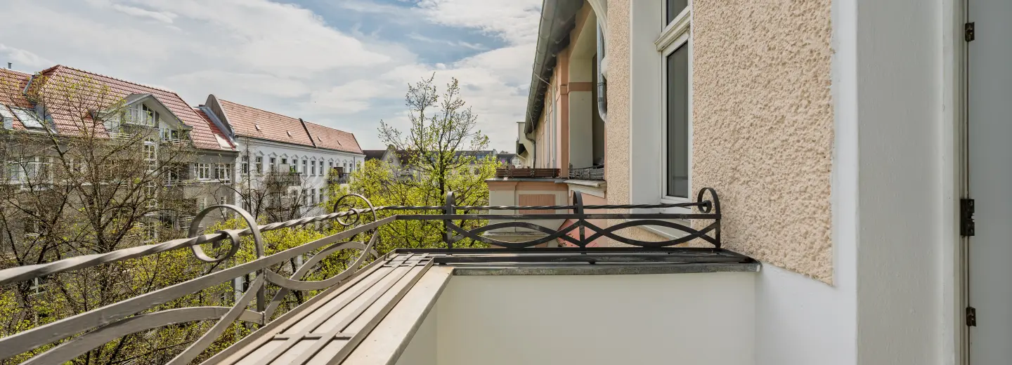 Balkon mit Blick in die begrünte Straße