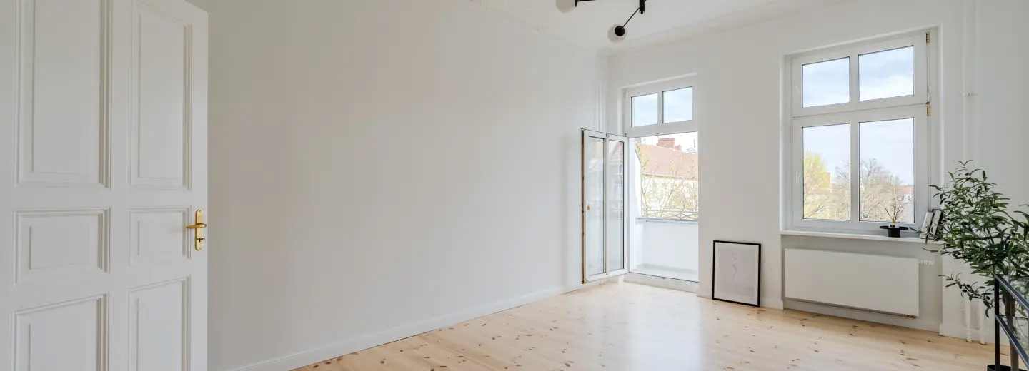 Wohnzimmer mit Fensterfront und Balkonzugang