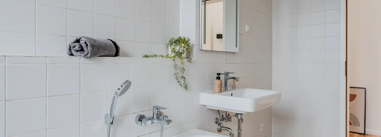 Das Badezimmer kombiniert zeitlose Fliesen mit neuen Sanitärobjekten