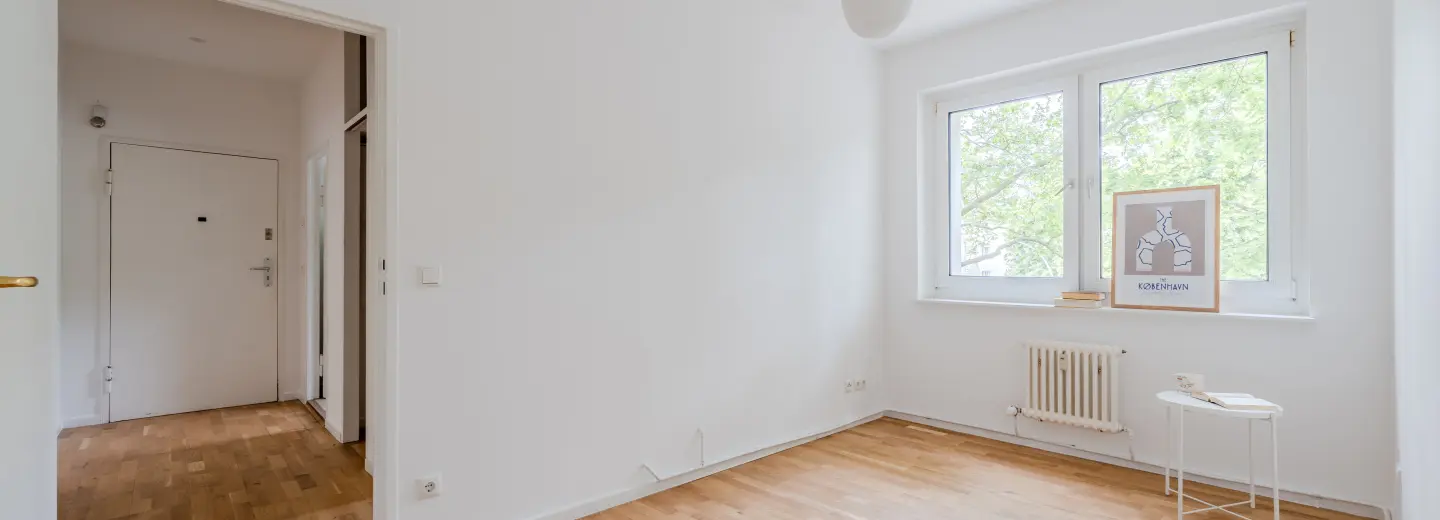 Heller Wohnbereich mit großem Fenster und Parkett