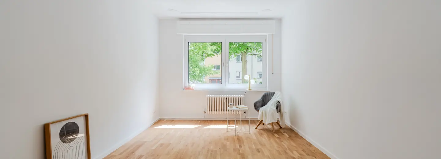 Wohnraum mit großem Fenster und Stuckdecke