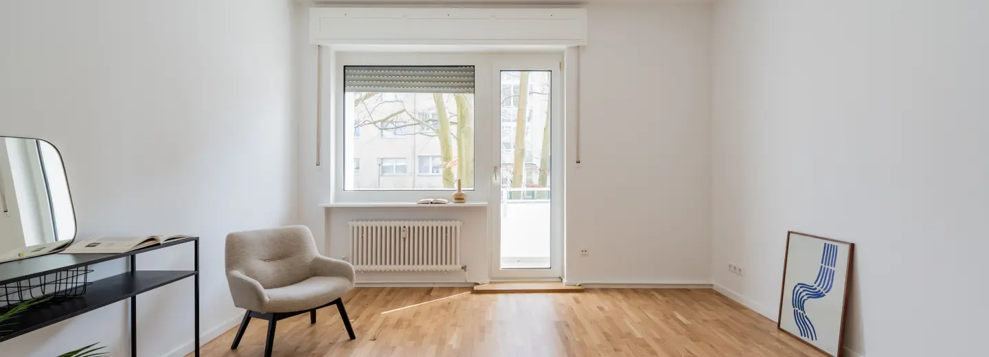 Wohnzimmer mit Balkontür und Parkett