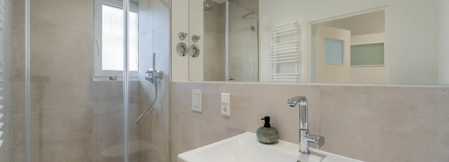 Modernes Bad mit Dusche und Waschtisch