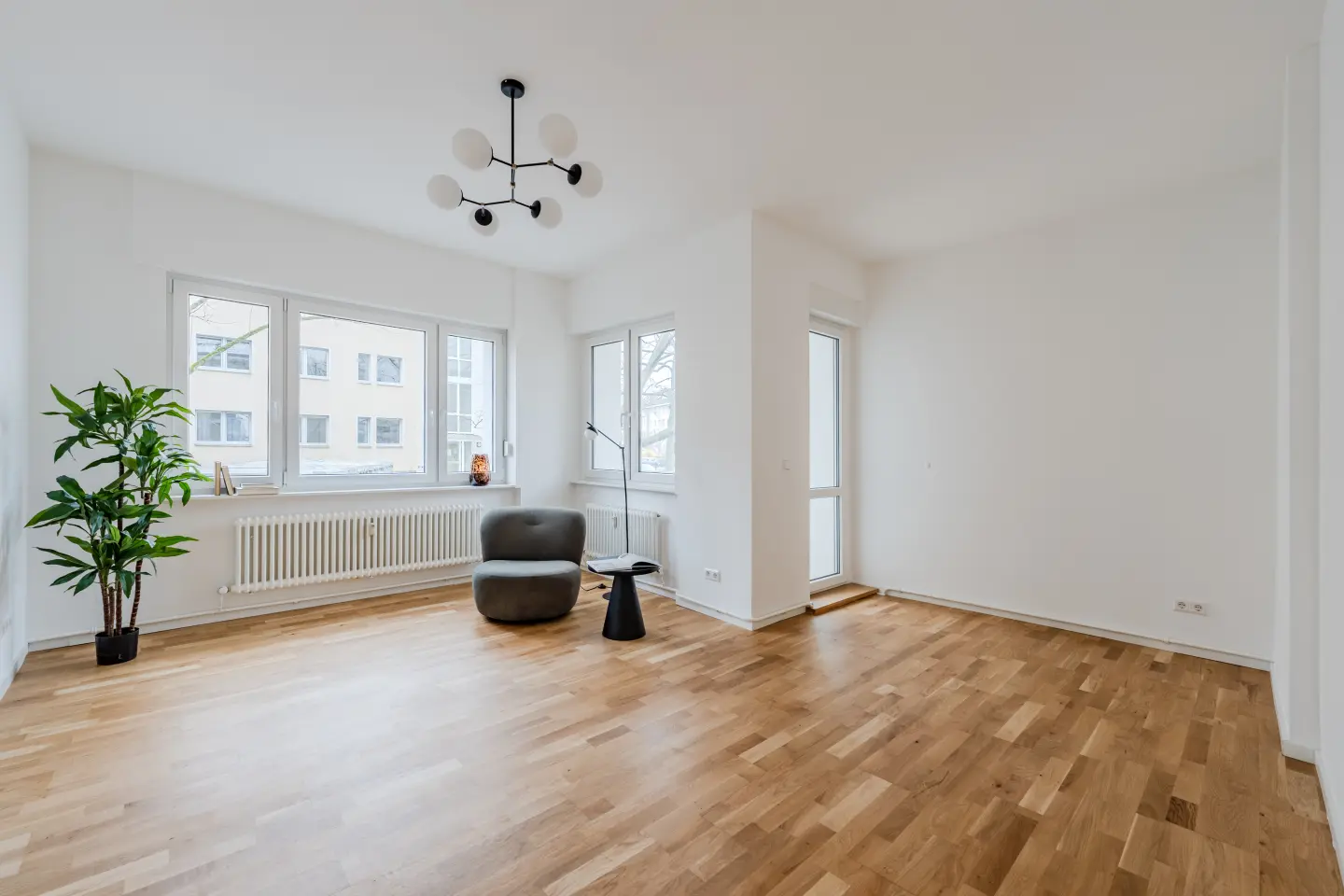 Wohnzimmer mit Parkettboden und Balkontür