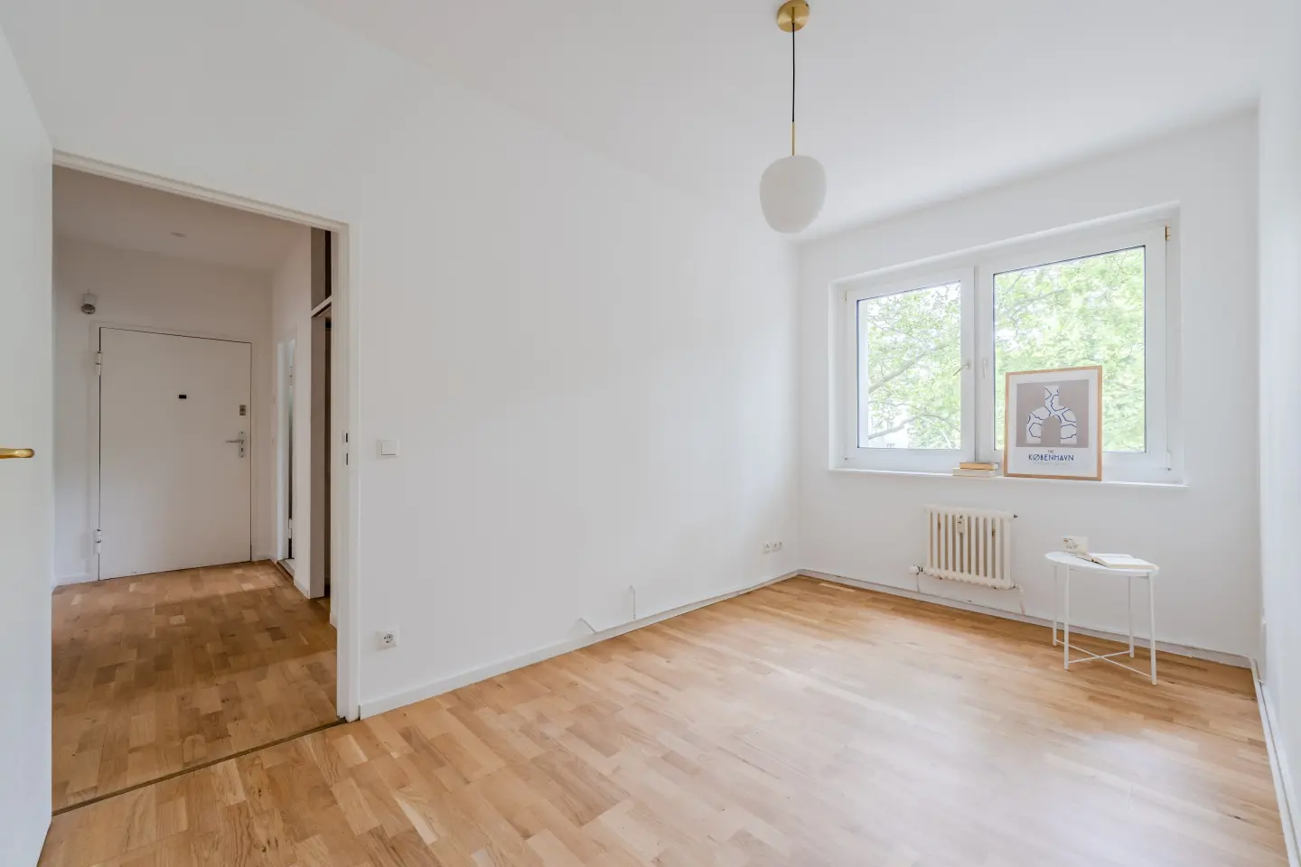 Heller Wohnbereich mit großem Fenster und Parkett