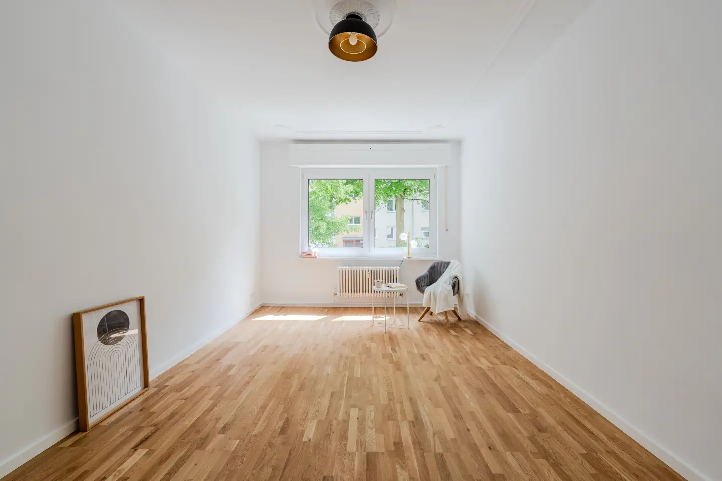 Wohnraum mit großem Fenster und Stuckdecke