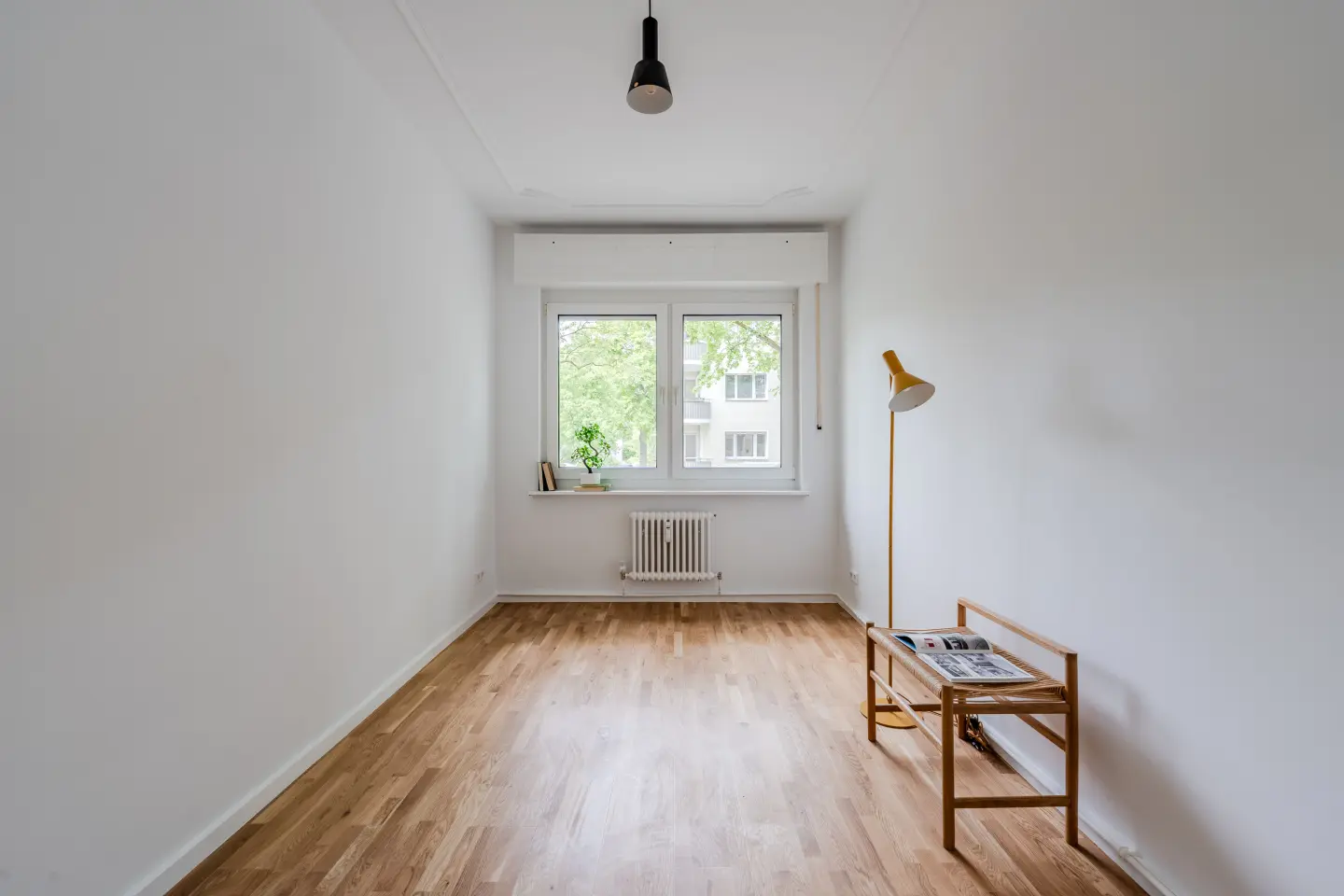 Wohnraum aus zweiter Perspektive mit Fensterfront