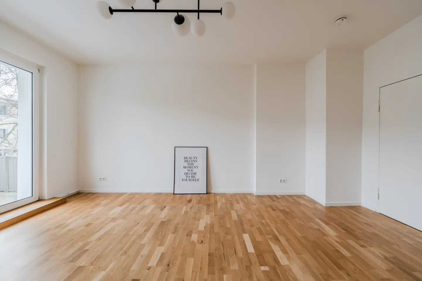 Wohnzimmer mit Parkett und Balkontür