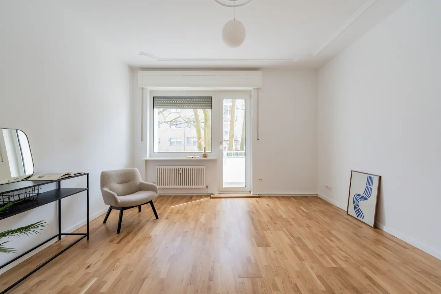 Wohnzimmer mit Balkontür und Parkett