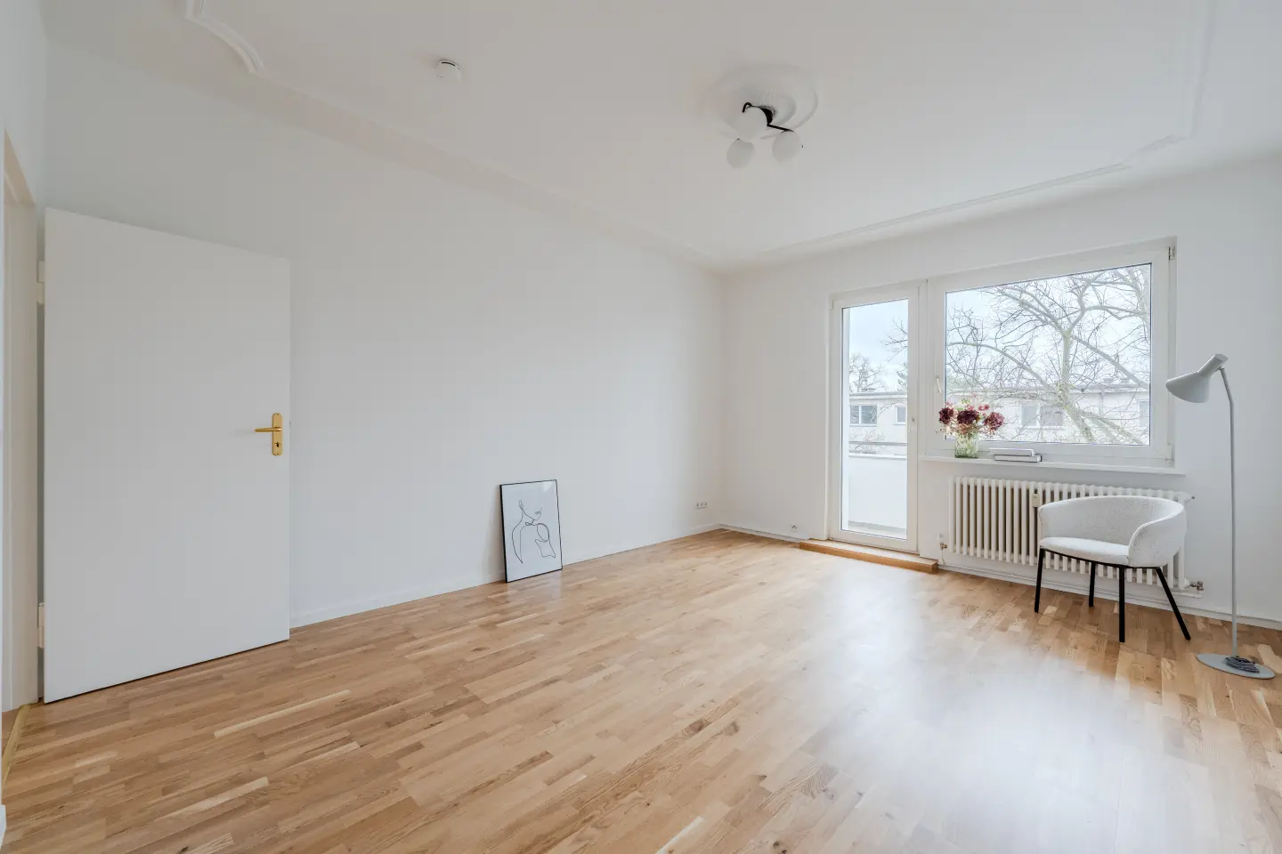 Wohnzimmer mit Balkontür, Parkett und Stuckdecke