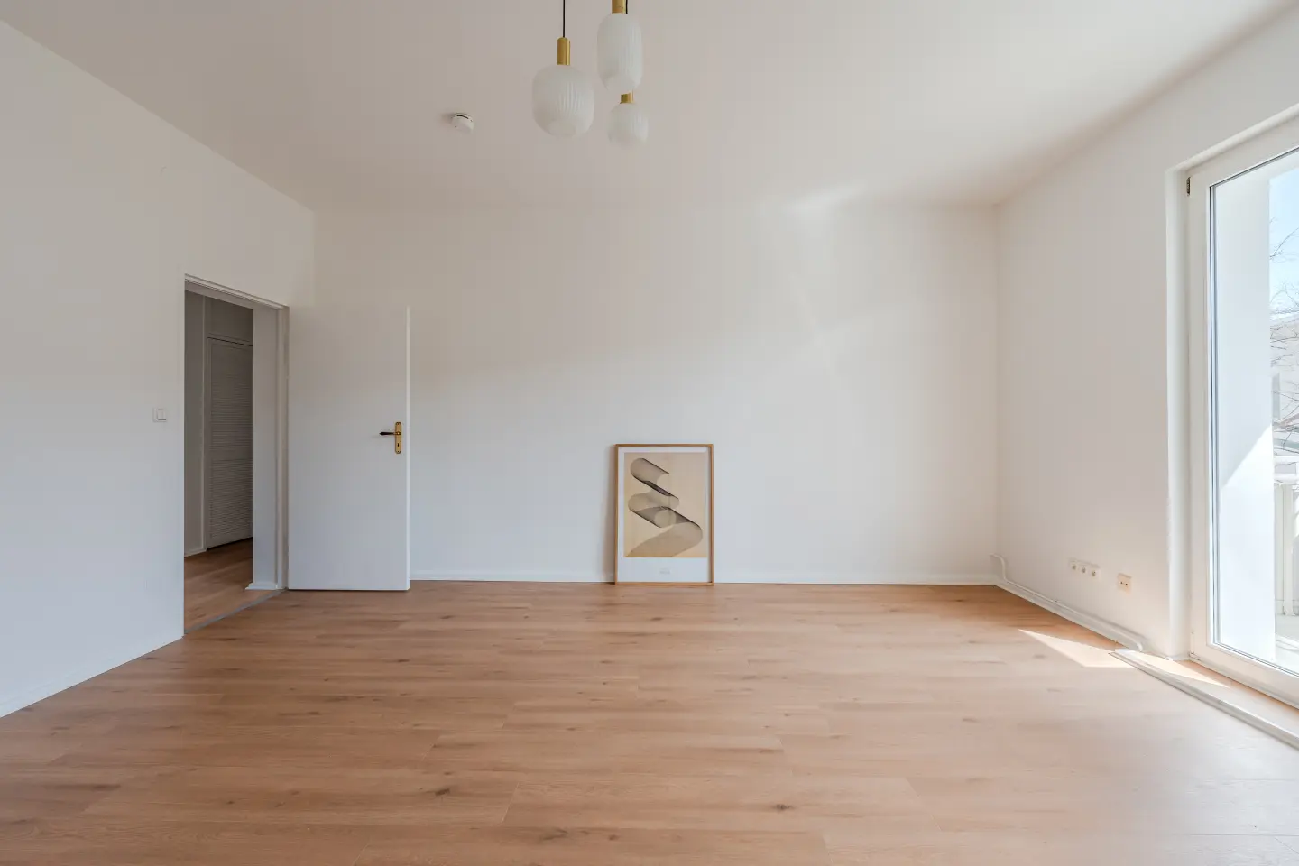 Wohnzimmer mit Parkett und Balkontür