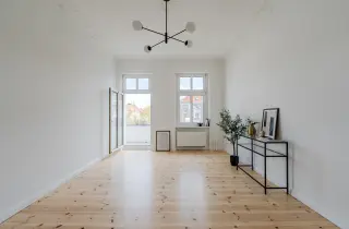 Wohnzimmer mit Balkonzugang und Dielenboden