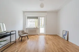 Wohnzimmer mit Balkontür und Parkett