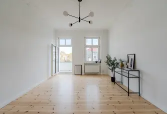 Wohnzimmer mit Balkonzugang und Dielenboden