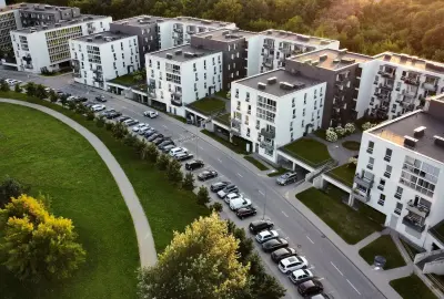 Luftaufnahme eines modernen Wohnkomplexes mit mehreren Mehrfamilienhäusern und Parkplätzen – Eigentumswohnungen zur Vermietung