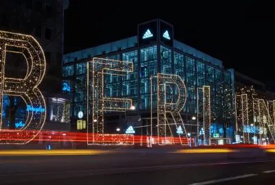Illuminated Berlin sign made of large light letters at night with passing cars and light trails