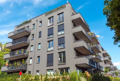 Neubau-Wohnanlage mit mehreren Balkonen und Grünflächen.
