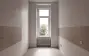 Separate Küche mit Fenster und heller Fliese