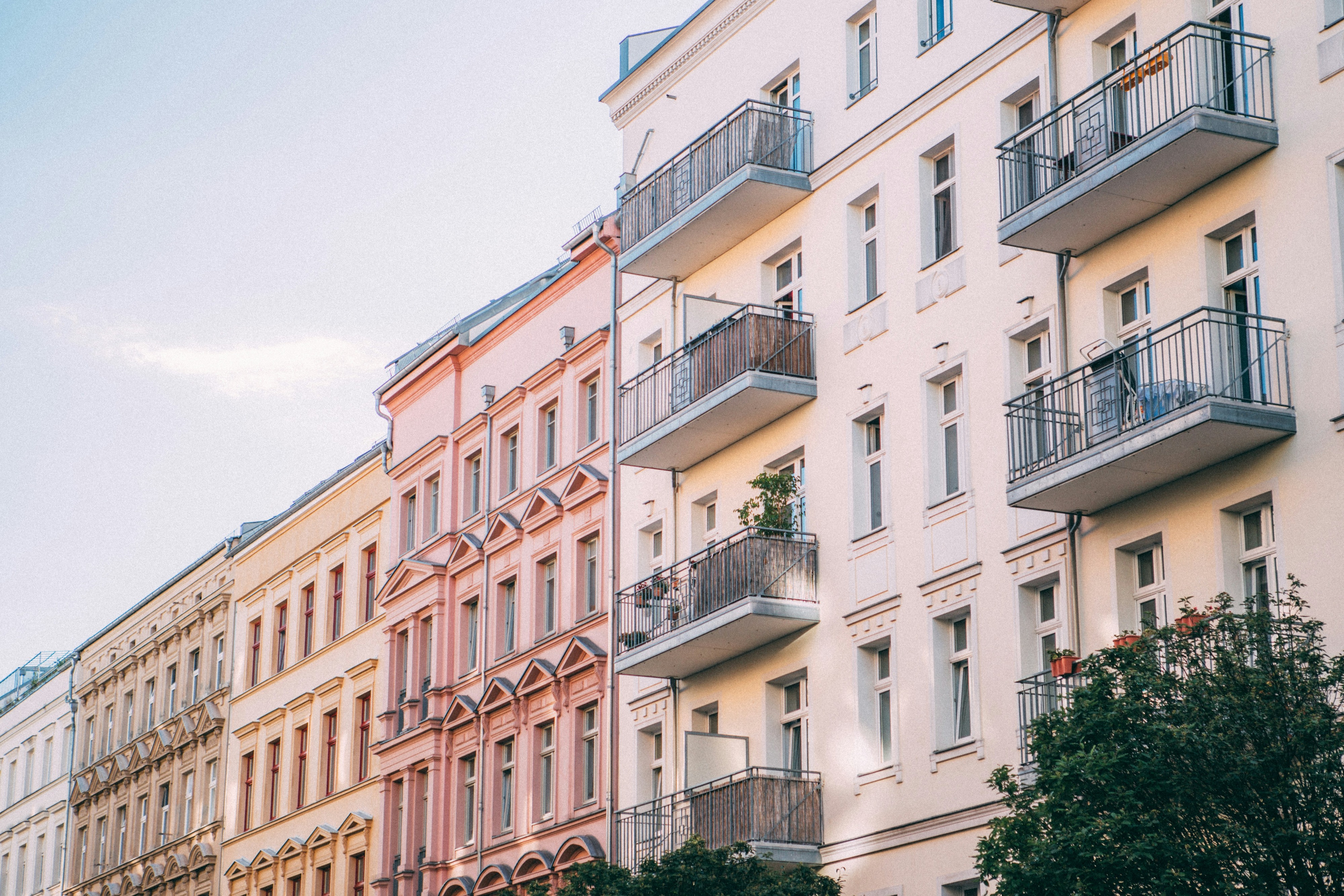 Historic apartment buildings with balconies in pastel colors, photographed from below