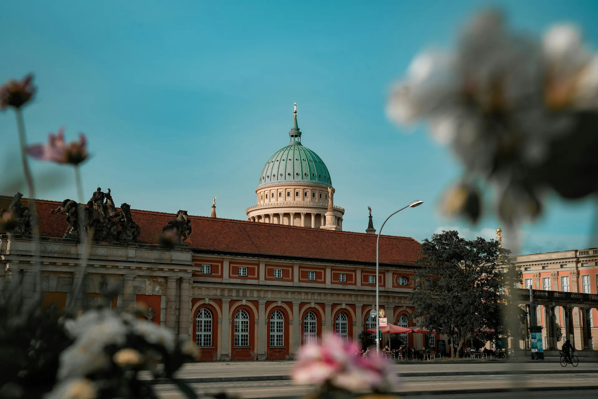 Domed historic building with blurred flowers in the foreground.