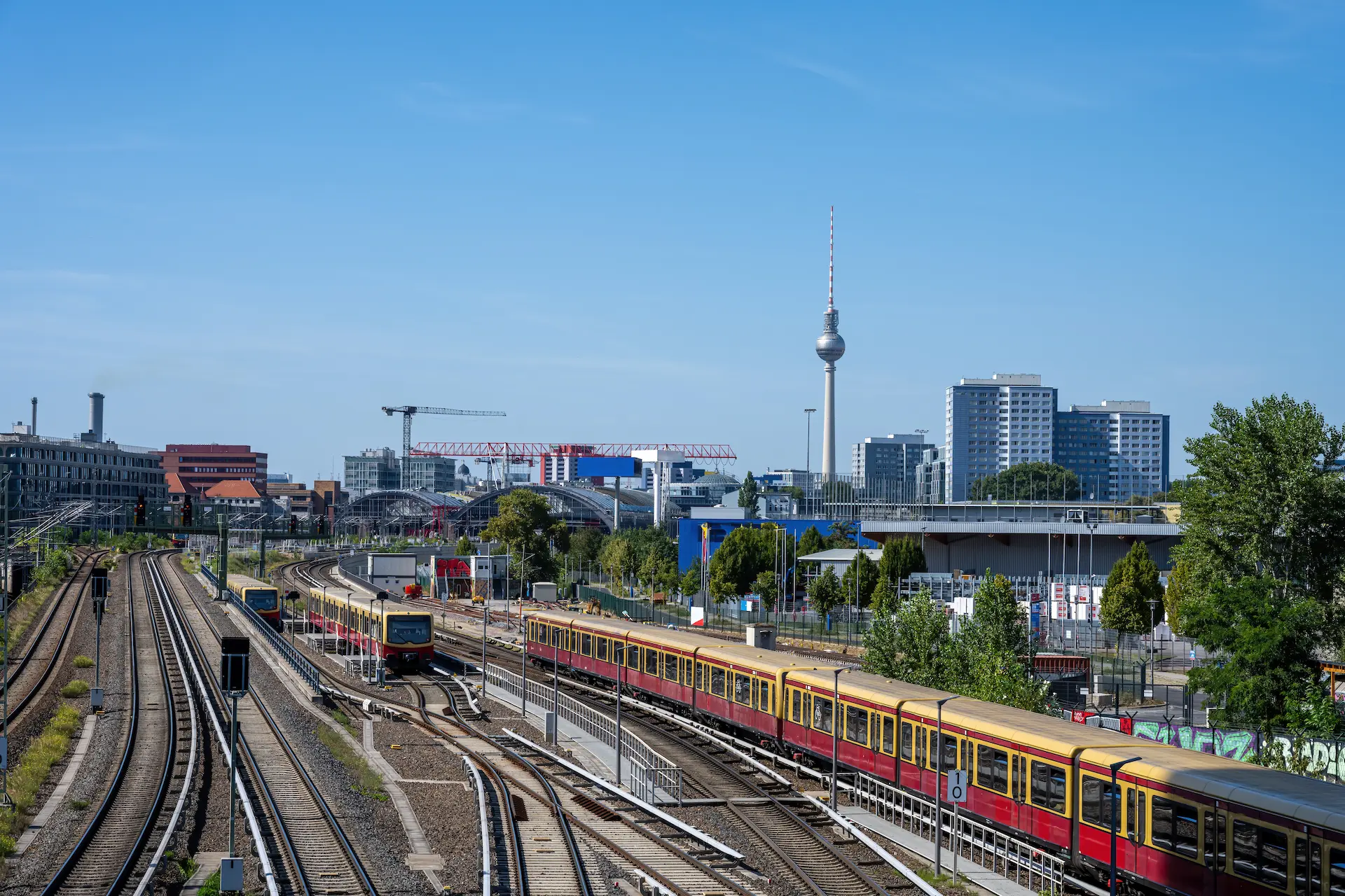 Berlin S Bahn trains on multiple tracks with city skyline