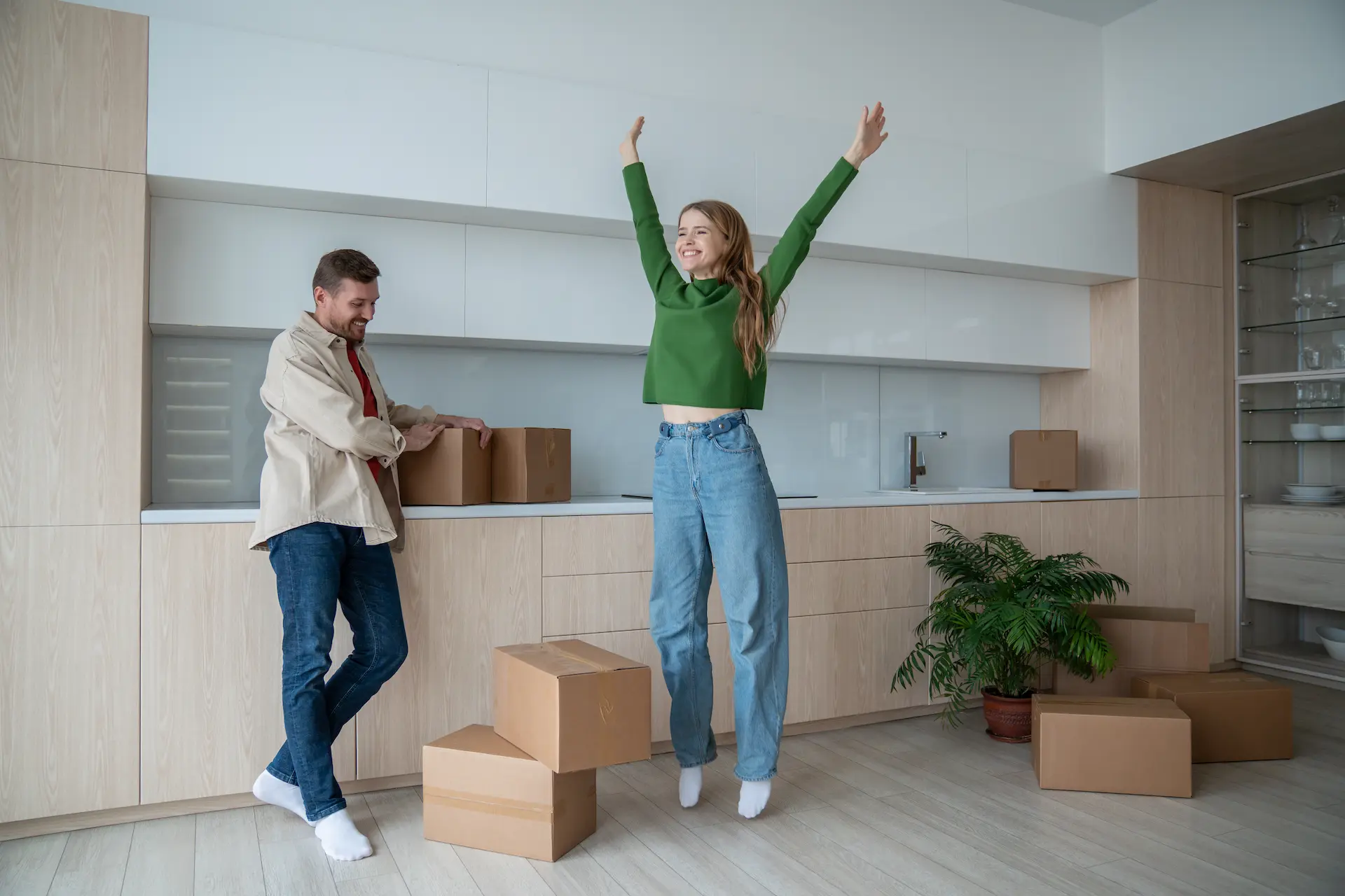 Couple celebrating moving into a new home with moving boxes.