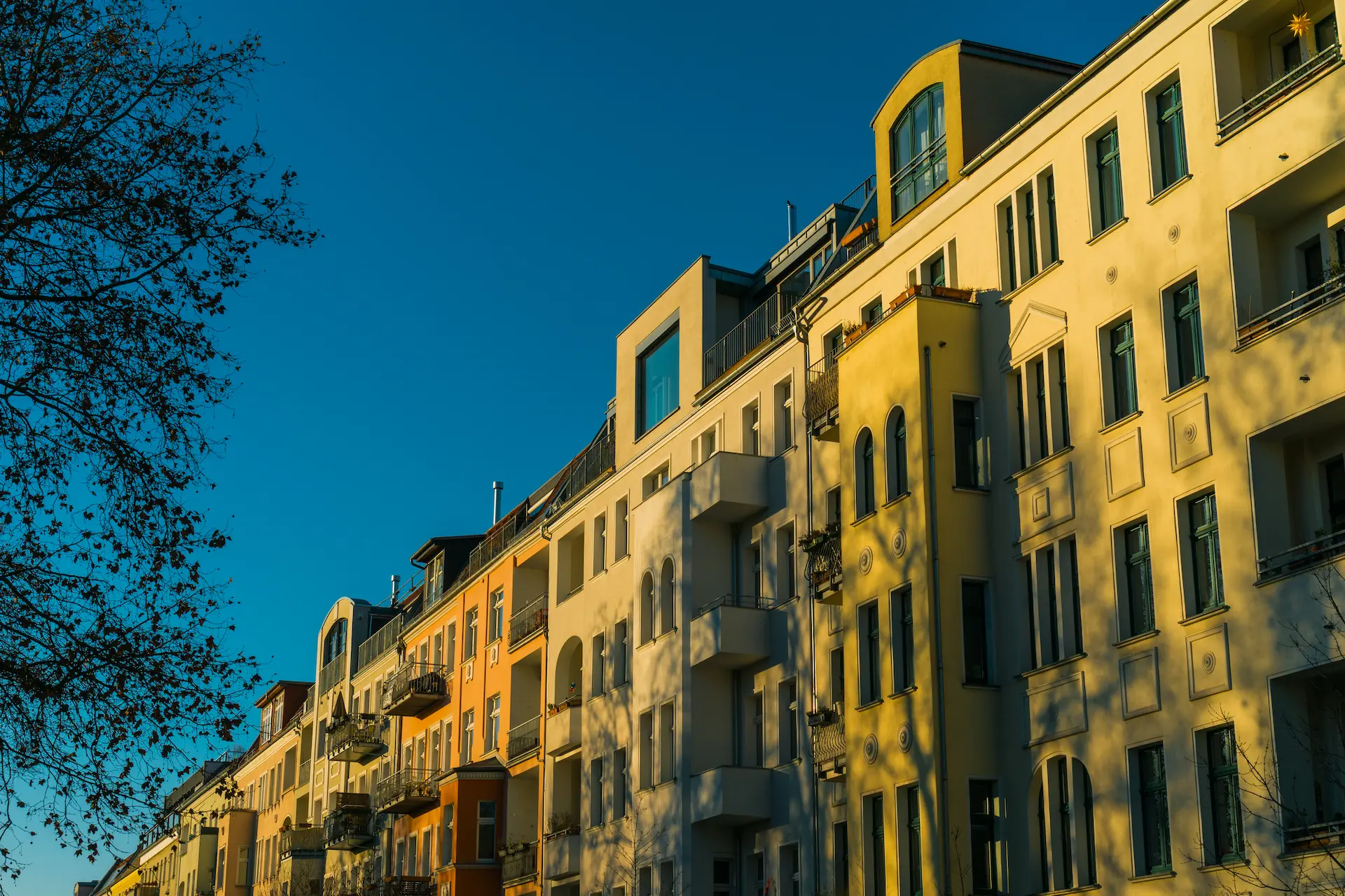 Colorful residential buildings along a city street in warm evening light.